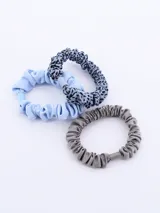 Pack de tres coleros para el pelo, uno color crema, uno con estampado dálmata y uno negro.