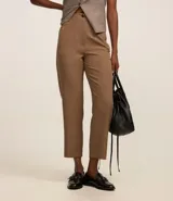 Pantalón zanahoria de sastrería color blanco, con cintura alta, trabillas y botón contrastante.