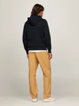 Buzo negro con capucha de Tommy Hilfiger. Tiene el logo de la marca bordado en blanco en el pecho y el logo de la bandera en el puño.