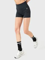 Calza corta tipo biker de tiro alto, color negro, diseñada para actividades deportivas como yoga o pilates. Presenta un ajuste al cuerpo con banda de silicona para mayor sujeción y libertad de movimiento.