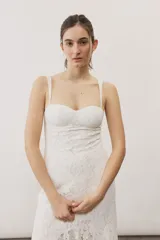 Vestido largo de encaje blanco con tirantes finos y silueta ajustada.