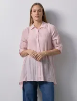 Camisa larga de rayón, con cuello clásico, cierre frontal con botones y mangas regulables con presilla. Presenta un diseño holgado con tajos laterales en el ruedo.