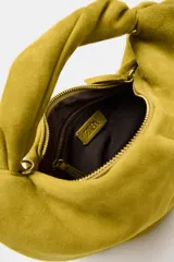 Bolso de mano de piel color verde mostaza, con cuerpo fruncido, asa de mano con detalle retorcido, cadena metálica opcional para función bandolera y cierre mediante cremallera.