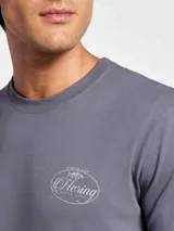 Remera blanca de manga corta con cuello redondo y estampa frontal con diseño gráfico de club de pesca en tonos azul y rojo.