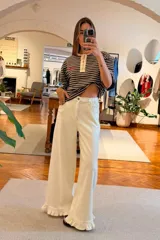 Jeans de tiro alto en color beige, con cintura elastizada en la espalda, corte oxford y volado en el ruedo.