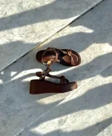 Sandalias de cuero color marrón chocolate, con plataforma y tira delantera ancha con nudo.