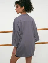 Remera deportiva de manga corta rosada, con escote en V y corte oversized de tejido dry fit.