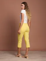 Pantalón capri blanco de gabardina elastizada. Pretina ancha elastizada, delantera con bolsillos simulados y trasera con bolsillos aplicados.