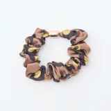 Set de cuatro gomas para el pelo tipo scrunchie, dos en color verde oliva liso y dos con estampado animal print, todas con detalle metálico central.