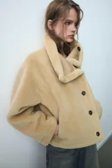 Cazadora reversible de cuello subido y manga larga, con bolsillos de vivo en el delantero y cierre frontal con botones. Confeccionada en tejido combinado con efecto pelo y efecto ante.