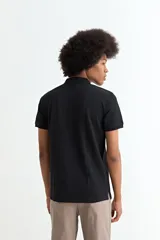 Remera tipo polo de manga corta, color negro, con cuello clásico y cierre frontal de tres botones.