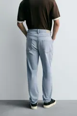 Pantalón de jean corte slim fit, color gris con efecto lavado. Presenta diseño de cinco bolsillos, cierre frontal con cremallera y botón, y tejido elástico.