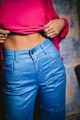 Pantalón jean de tiro alto color azul metálico, con bolsillos delanteros y traseros.