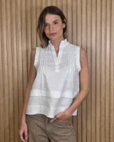 Musculosa blanca sin mangas de lino con cuello mao, escote en V y detalles de alforzas y pliegues con pespuntes en el frente.