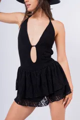 Vestido corto negro de encaje con escote halter, abertura en el pecho y falda de volantes.
