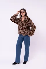 Campera de piel sintética con estampado animal print de leopardo, corte holgado, cuello alto y cierre frontal completo.