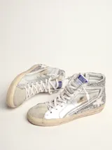 Zapatillas deportivas de caña alta plateadas con glitter, estrella blanca y suela color crema.