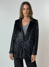 Blazer negro de terciopelo con solapas y cierre frontal con un botón.