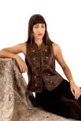 Chaleco de cuero vacuno envejecido color cognac, con diseño de estilo vintage, cuello mao y cierre frontal con botones decorativos de época y tientos para atar.