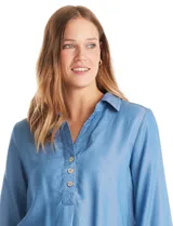 Blusa de lyocell color azul, con cuello camisero, escote en V con cierre de botones y mangas tres cuartos amplias. Presenta un corte holgado con tajos laterales en el ruedo.