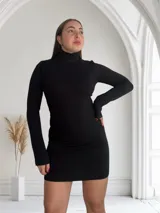 Minivestido negro de punto canalé, con cuello alto y mangas largas.