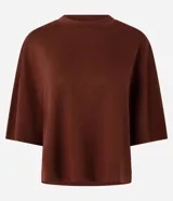 Remera de modal color crudo, con diseño minimalista, calce amplio, cuello redondo y mangas cortas amplias con hombros caídos.