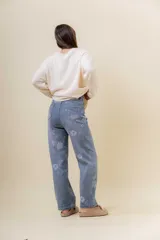Pantalón de jean de corte recto y relajado, con tiro medio-alto. Presenta un estampado floral sutil en tonos claros sobre la base de denim azul y cuenta con interior forrado para mayor abrigo.