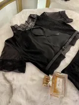 Conjunto de lencería compuesto por un top de cuello alto con mangas cortas y una bombacha de tiro alto. Ambas piezas combinan paneles de terciopelo, microtul transparente y detalles de encaje elastizado.