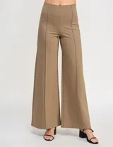 Pantalón de tiro alto con corte wide leg, confeccionado en tejido elastizado. Presenta una costura vertical decorativa en el frente de cada pierna y un diseño de calce cómodo.