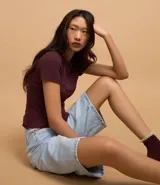 Blusa básica de manga corta, cuello redondo y textura sutil, confeccionada en viscosa con elastano. El bajo de la prenda es ondulado.