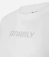 Remera de algodón color blanco tiza, de corte ajustado al cuerpo, cuello redondo y manga corta. Presenta la palabra "GNARLY" estampada en el centro del pecho con apliques de strass plateados.
