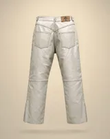 Pantalón flare de cuero vacuno en color hueso, con tiro alto y diseño ajustado con abertura en los tobillos.