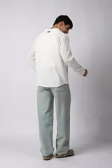 Camisa de manga larga confeccionada en tejido de lino con textura, de corte holgado y diseño versátil con cierre frontal de botones.