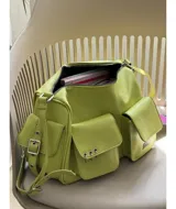 Bandolera color verde lima de tamaño grande, con dos bolsillos frontales y dos bolsillos laterales con broche imán. Tiene correa regulable y extraíble, interior forrado y bolsillo interno con cierre.