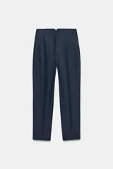 Pantalón de tiro alto y corte slim fit, color azul marino con diseño de rayas diplomáticas. Es de largo tobillero, cuenta con bolsillos delanteros de vivo y costuras marcadas en el delantero y la espalda. Cierre frontal con cremallera, botón interior y gancho metálico.