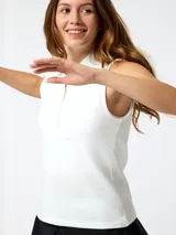 Remera polo sin mangas de piqué blanco, con cuello camisero y tapeta de botones frontal.