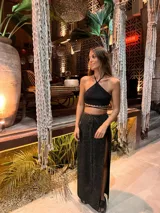 Falda larga de punto con acabado brillante de lurex, diseño cruzado con tajo lateral profundo.