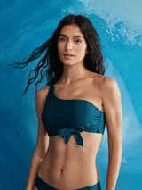 Top de bikini estilo bandeau asimétrico, color verde azulado oscuro, con un nudo decorativo en el centro del busto.
