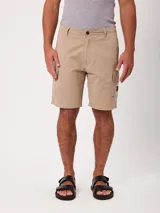 Bermuda cargo lisa color beige, con bolsillos laterales en las piernas y cierre frontal con botón y cremallera.