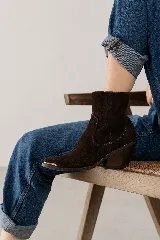 Bota corta de cuero vacuno color marrón topo, con diseño de estilo western, taco cuadrado de 7 cm y puntera metálica decorativa. Cuenta con cierre lateral interno para facilitar el calce.