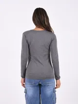 Remera básica de color blanco, con cuello redondo amplio y mangas largas, de diseño entallado.