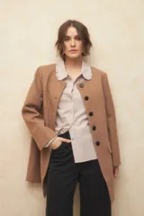 Tapado largo color crema, de paño, con cuello a la base y botones redondos veteados.