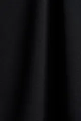 Top corto negro de punto elástico de viscosa, con escote bote, hombros caídos y mangas cortas amplias. Presenta una sección superior superpuesta con diseño asimétrico efecto capa.