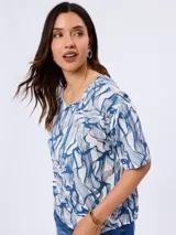 Blusa de viscosa con cuello redondo y mangas cortas, con diseño estampado en tonos azules y blancos.