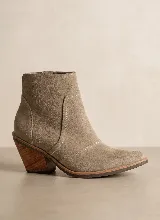 Bota corta de cuero vacuno en color azul oscuro, con diseño de caña media, punta almendrada y taco cuadrado de 7 cm. Presenta costuras decorativas laterales y suela de caucho antideslizante.