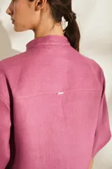 Camisa de lino color fucsia, con cuello mao, mangas cortas holgadas y cierre frontal con botones de madera. Cuenta con bolsillos frontales en el pecho.