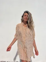 Vestido camisero color beige con bordado vertical en color blanco, de corte recto, cuello mao y mangas cortas con trabilla.