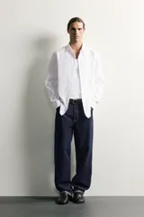 Camisa de corte slim fit confeccionada en tejido de fácil planchado, con cuello italiano, manga larga con puños abotonados y cierre frontal de botones.