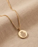 Collar de bronce dorado con cadena fina de eslabones y dije circular con la figura de una mano de Fátima (Hamsa) texturizada en el centro.