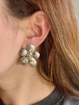 Aros caravanas de acero plateado con diseño de flor texturada.